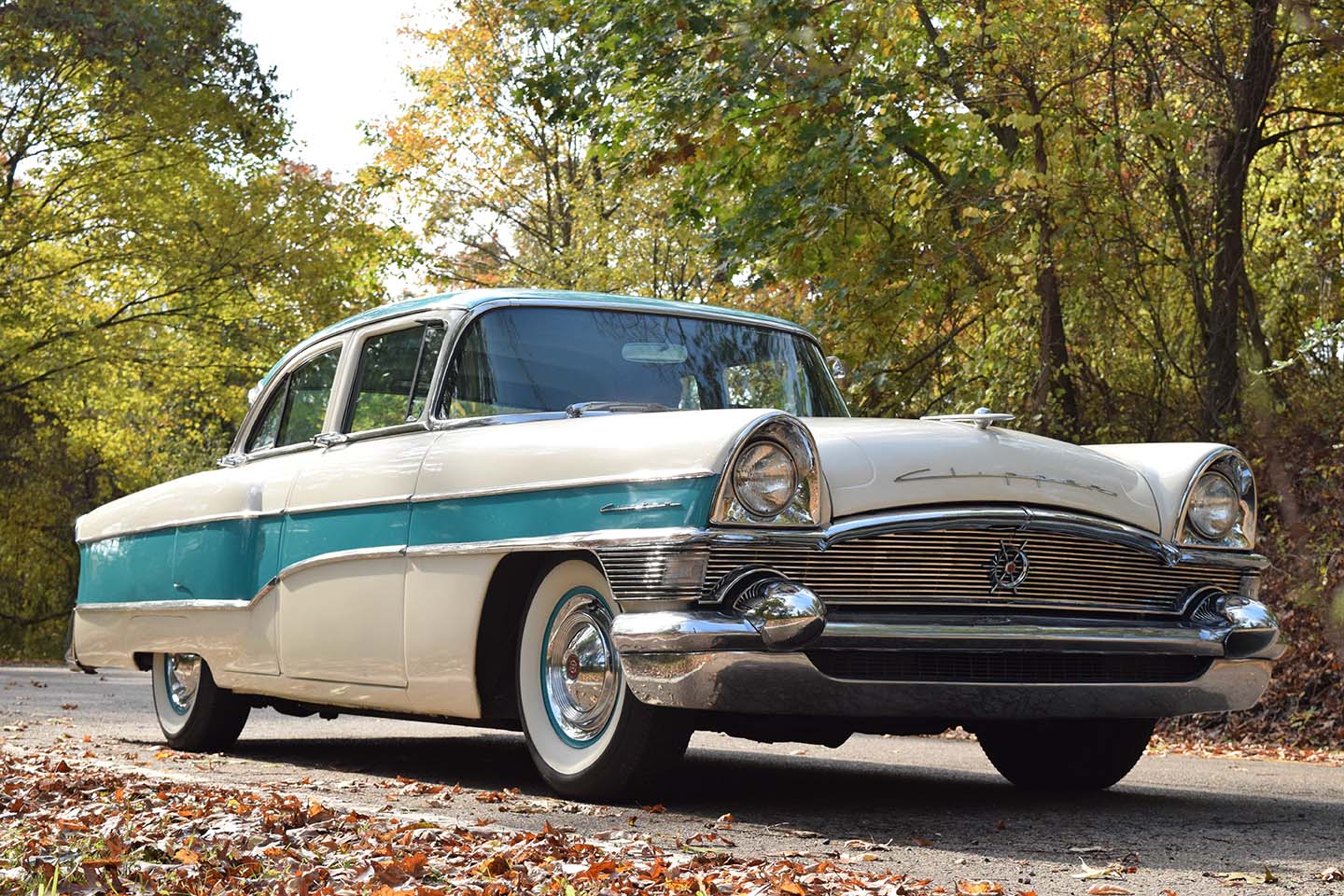 1956 Packard Clipper Custom parked on a country road in autumn. Front 3/4 view from passenger side low.